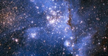 An image captured by the Hubble Telescope shows young stars spiraling into the center of a massive cluster of stars in the Small Magellanic Cloud, a satellite galaxy of the Milky Way, Sept. 8, 2022. (NASA via AFP)