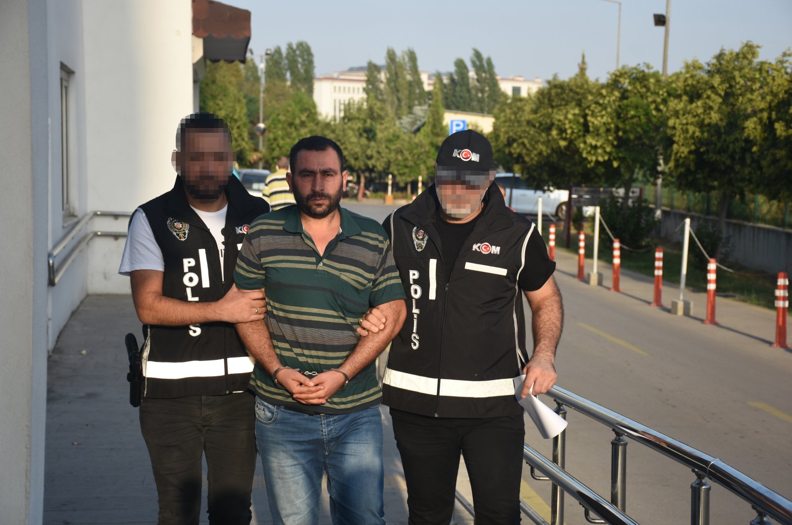 Police officers accompany a captured suspect, in Adana, southern Türkiye, Sept. 30, 2022. (AA PHOTO) 