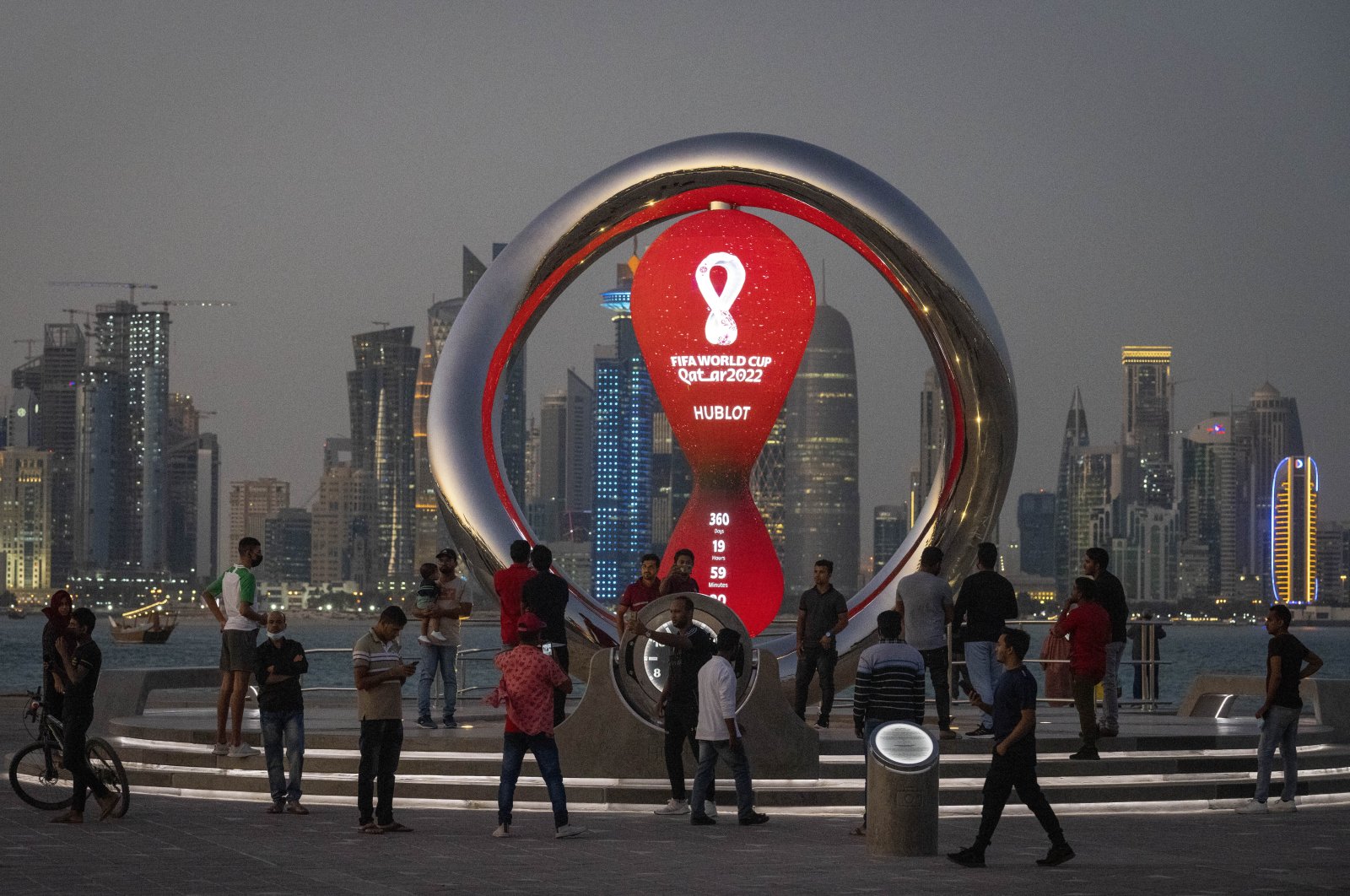 People gather around the official countdown clock showing the remaining time until the kickoff of the World Cup 2022, in Doha, Qatar, Nov. 25, 2021. (AP Photo)