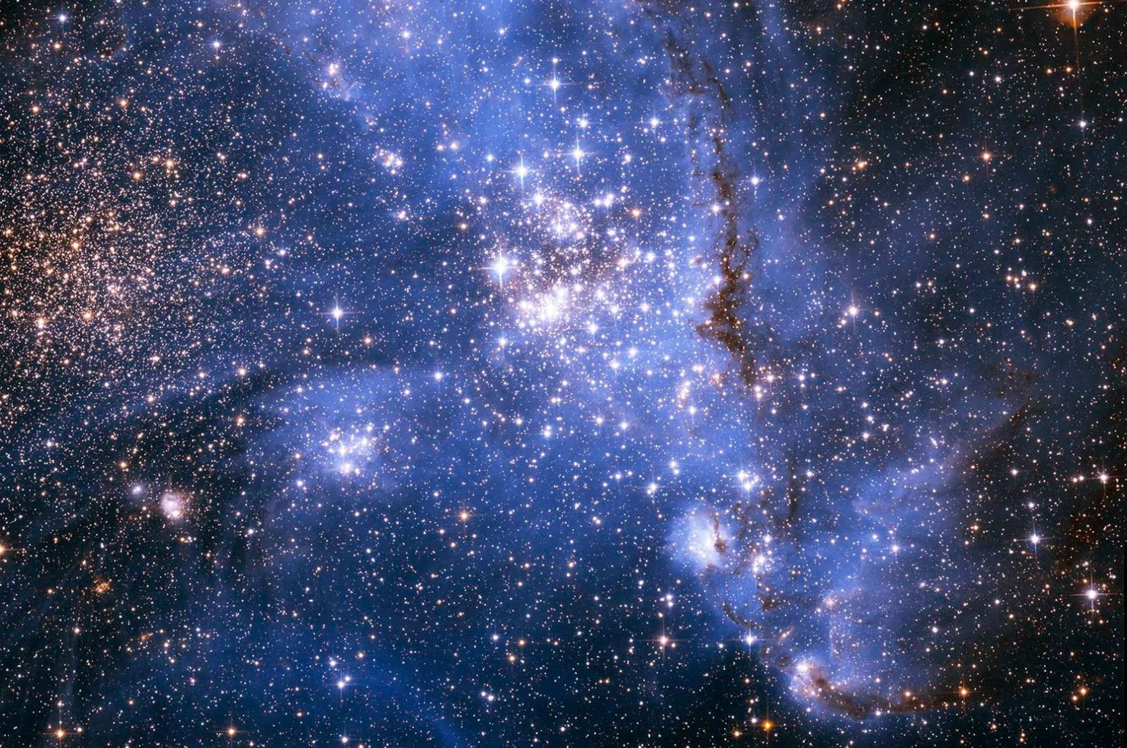 An image captured by the Hubble Telescope shows young stars spiraling into the center of a massive cluster of stars in the Small Magellanic Cloud, a satellite galaxy of the Milky Way, Sept. 8, 2022. (NASA via AFP)