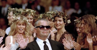 German fashion designer Karl Lagerfeld acknowledges the applause of his models at the end of the show he designed for the French fashion house Chanel, for the 1993-94 Fall-Winter haute couture collection, Paris, France, July 20, 1993. (AP Photo)