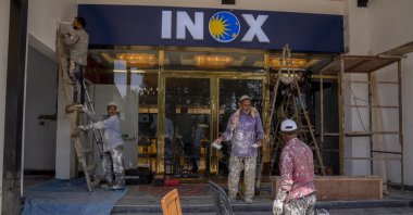 Laborers work outside the newly constructed "INOX" multiplex in Srinagar, Indian-occupied Kashmir, Sept. 19, 2022. (AP Photo)