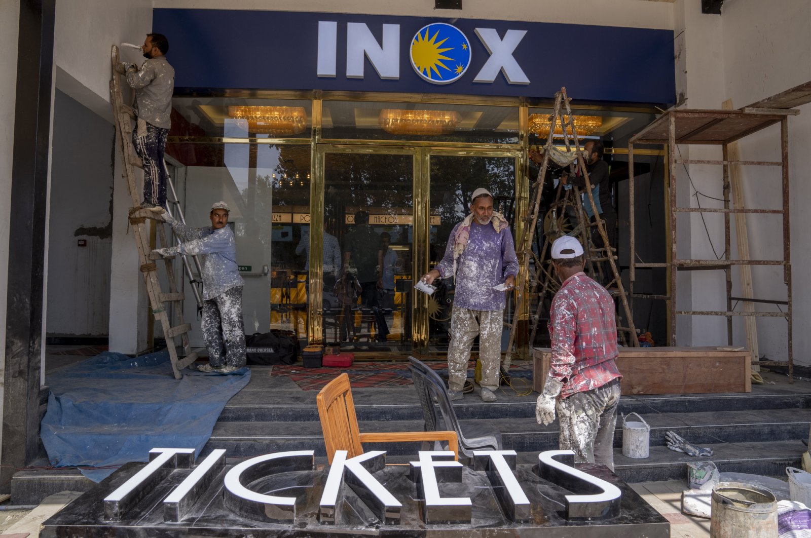 Laborers work outside the newly constructed "INOX" multiplex in Srinagar, Indian-occupied Kashmir, Sept. 19, 2022. (AP Photo)