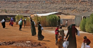 Syrians carry cleaning products distributed by a nonprofit organization at a camp for internally displaced people in the town of Sarmada in Syria's northwestern Idlib province, Sept. 25, 2022, as part of an awareness campaign about hygiene in a bid to stem an outbreak of cholera. (AFP Photo)