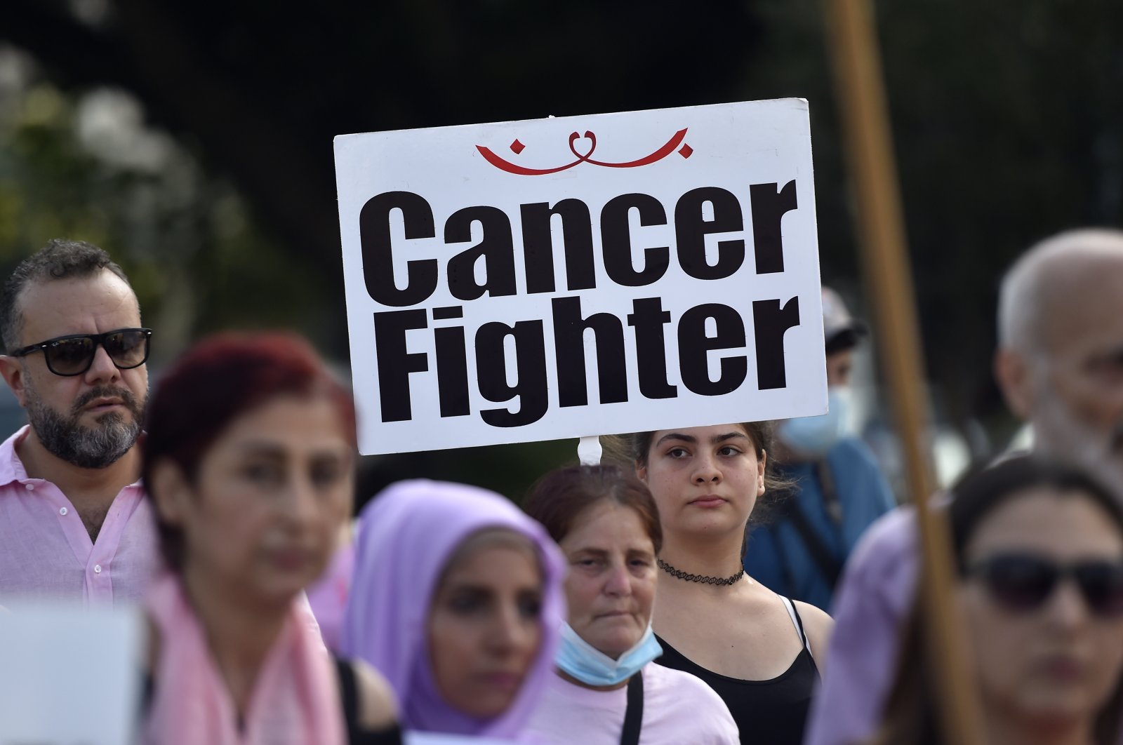 A Lebanese activist carries a placard &quot;Cancer Fighter&quot; during a march of solidarity with women diagnosed with breast cancer, in Beirut, Lebanon, Oct. 2, 2022. (EPA Photo)