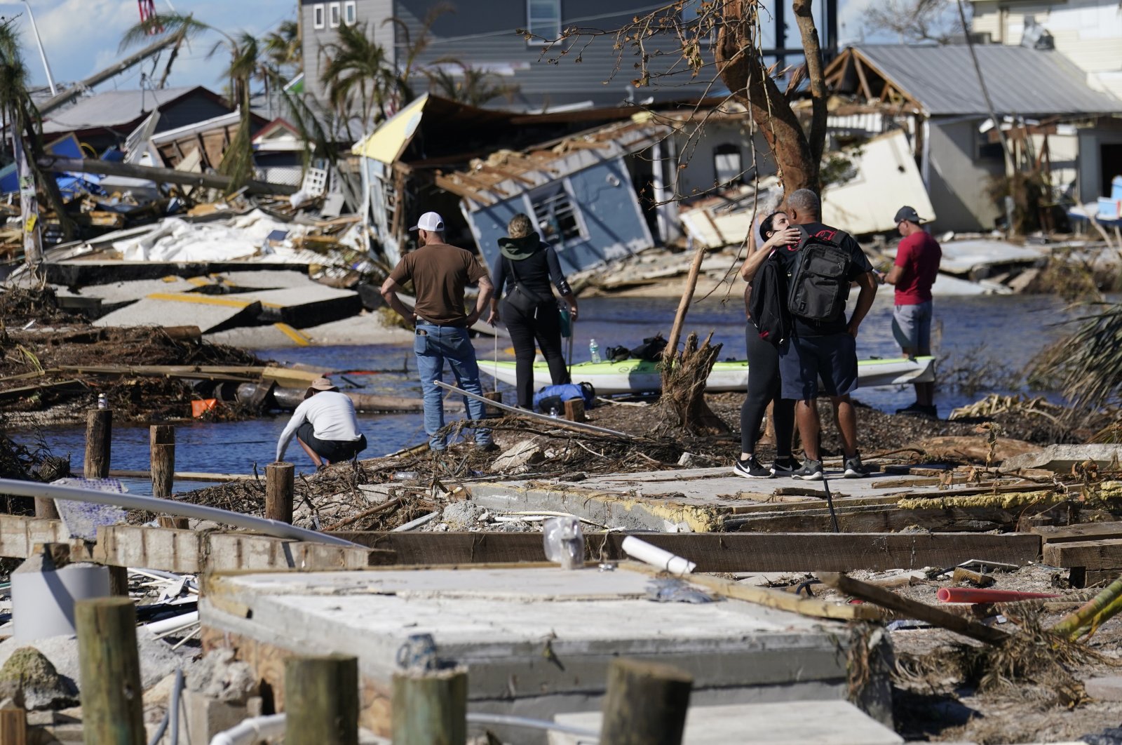 People stand on the destroyed bridge to Pine Island as they view the damage in the aftermath of Hurricane Ian, Spring Hill, Florida, U.S., Oct. 2, 2022. (AP Photo)