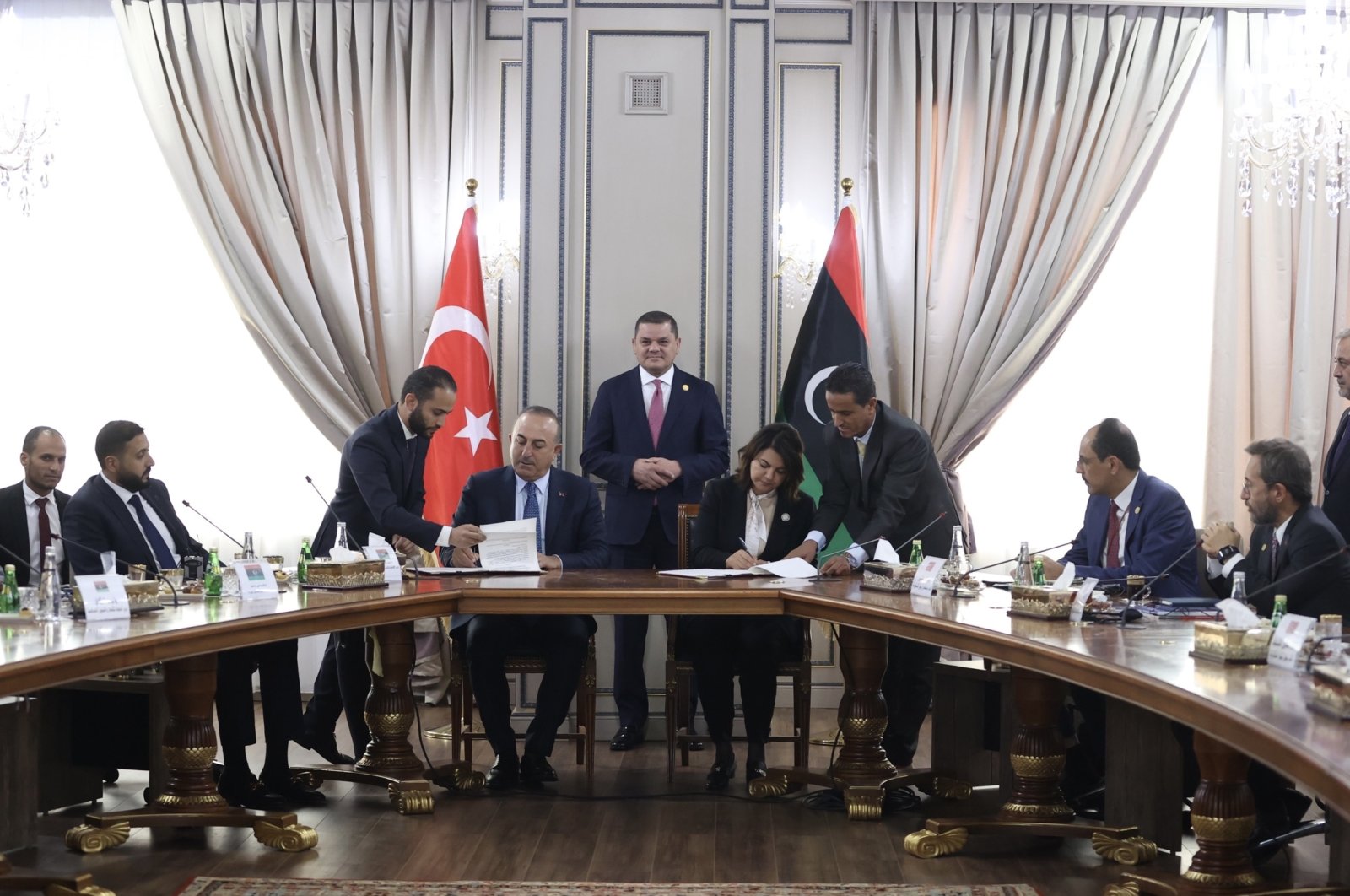 Leader of the Tripoli-based unity government and Prime Minister Abdul Hamid Mohammed Dbeibah (top C) oversees signing of agreements between Türkiye and Libya by Foreign Minister Mevlüt Çavuşoğlu (4th L) and Libyan Foreign Minister Najla Mangoush (4th R), in the capital Tripoli, Libya, Oct. 3, 2022.