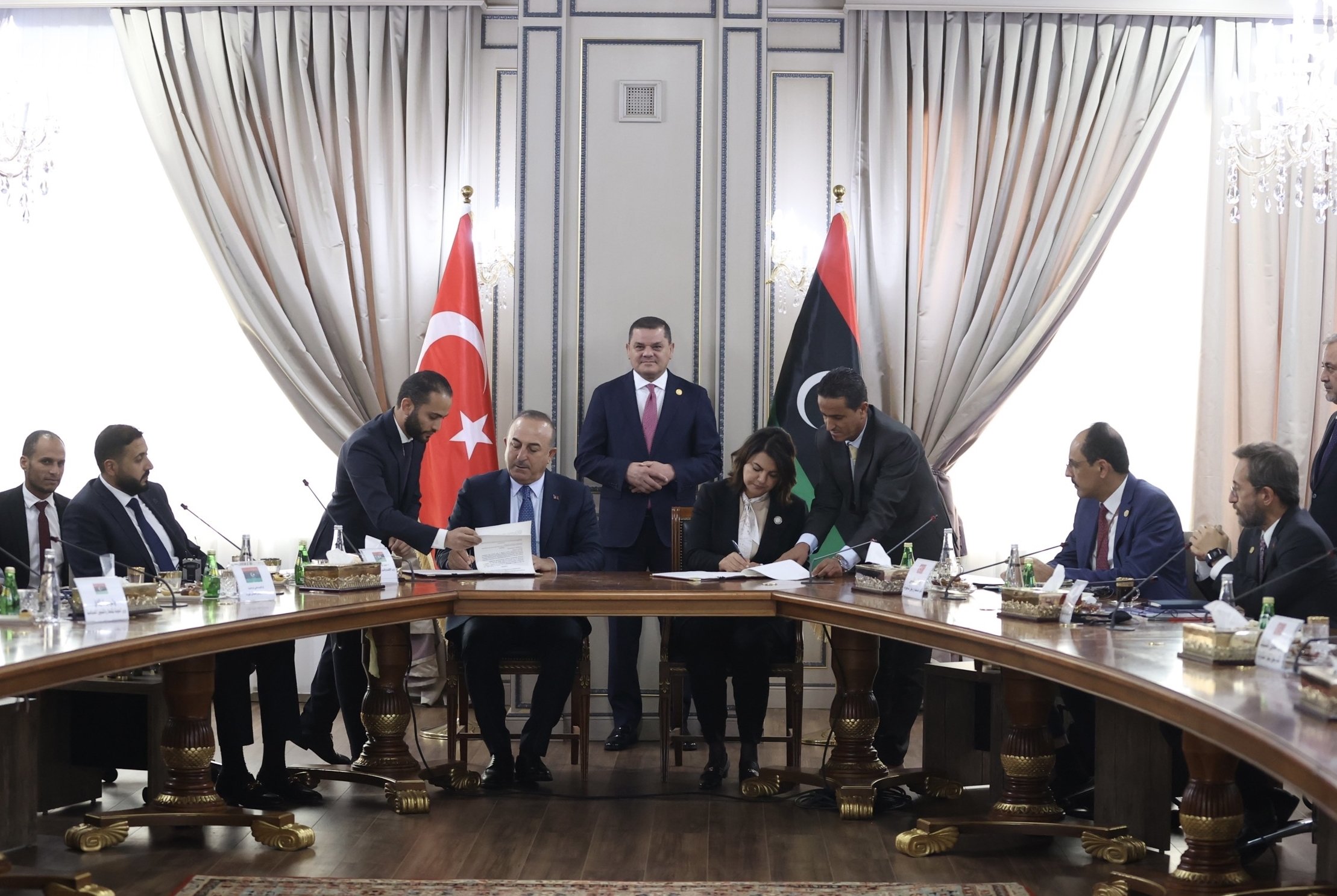 Pemimpin pemerintah persatuan yang berbasis di Tripoli dan Perdana Menteri Abdul Hamid Mohammed Dbeibah (atas C) mengawasi penandatanganan perjanjian antara Türkiye dan Libya oleh Menteri Luar Negeri Mevlüt Çavuşoğlu (ke-4) dan Menteri Luar Negeri Libya Najla Mangoush (ke-4), di ibu kota Tripoli, Libya, 3 Oktober 2022.