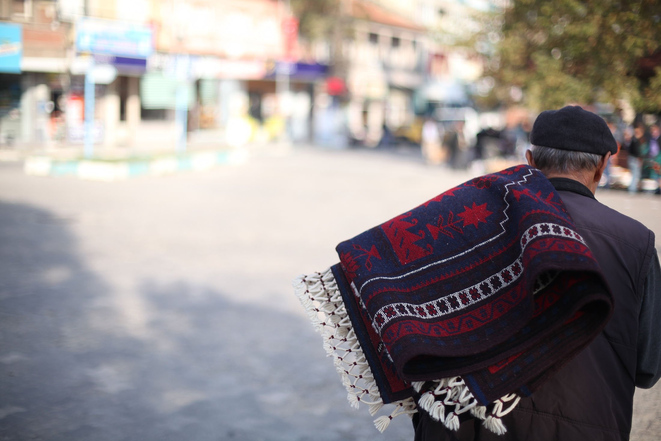 Seorang pria membawa karpet tradisional Yağcıbedir, di distrik Sındırgı di Balıkesir, Türkiye, 20 Mei 2016. (Foto Shutterstock)