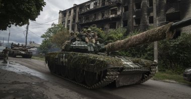 Ukrainian officers ride atop a tank in the recently recaptured city of Izium, Ukraine, Sept. 14, 2022. (AP Photo)