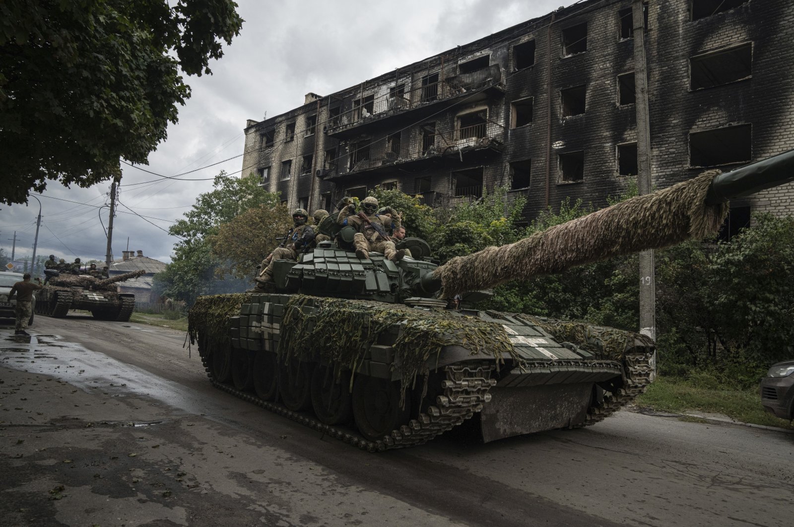 Ukrainian officers ride atop a tank in the recently recaptured city of Izium, Ukraine, Sept. 14, 2022. (AP Photo)