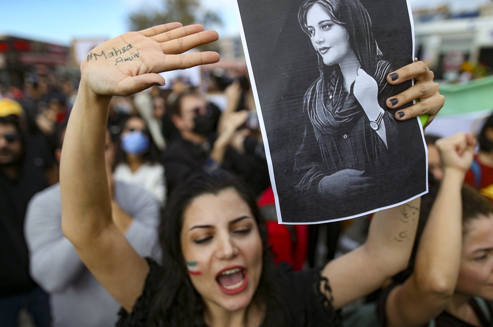 A woman holds up a drawing of Iranian Mahsa Amini as she shouts slogans during a protest against Amini&#039;s death, in Istanbul, Türkiye, Oct. 2, 2022. (AP Photo)