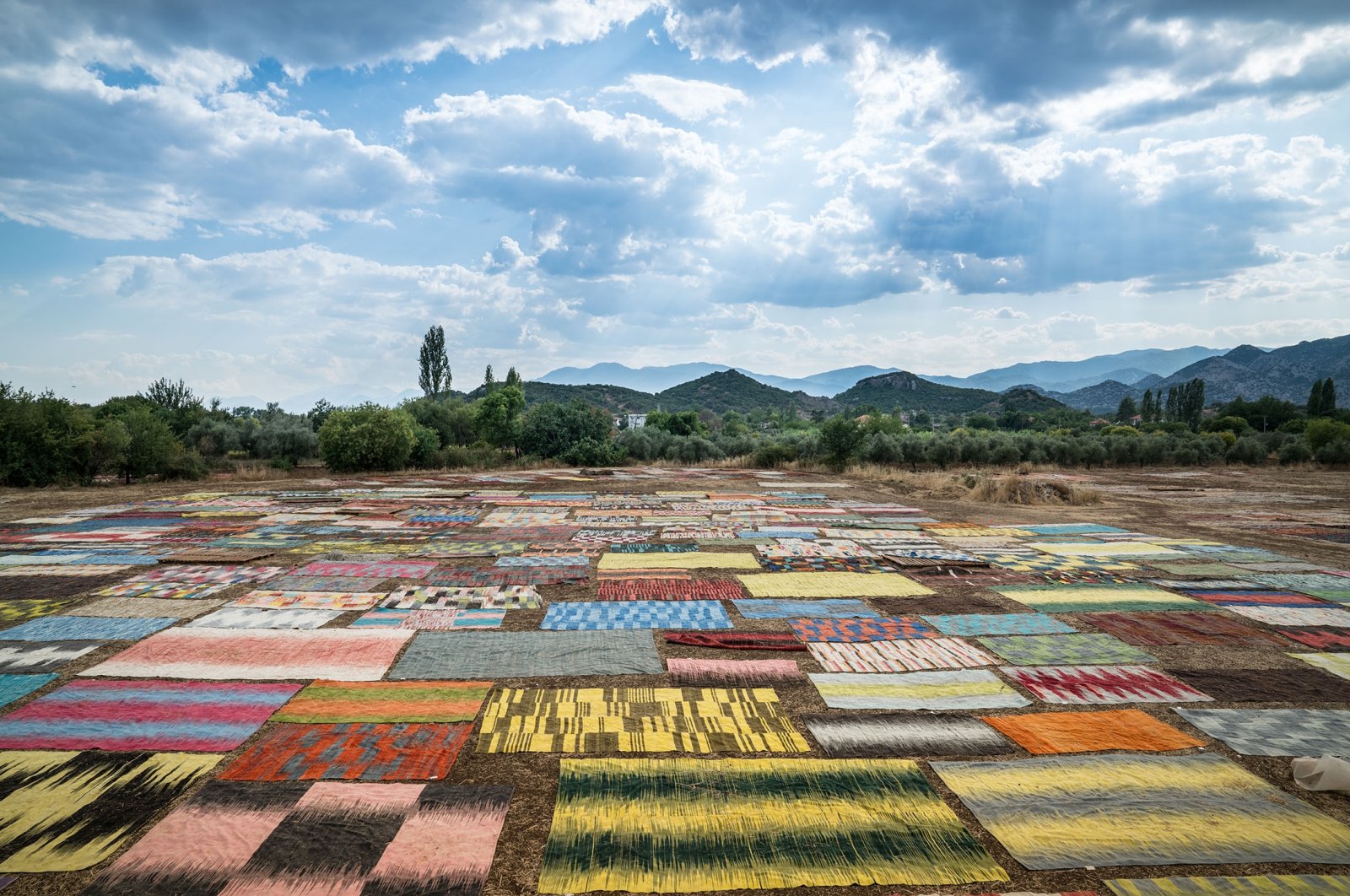 Carpets are laid out under the sun in a field, in Antalya, Türkiye. (Shutterstock Photo)