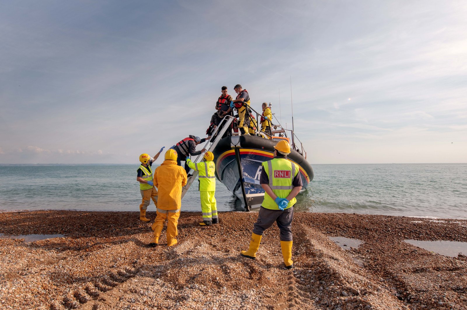 Royal National Lifeboat Institution shore crew help migrants disembark after being rescued in the English Channel, at Dungeness, Britain, Sept. 22, 2022. (EPA Photo)