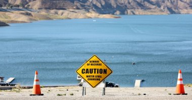 A caution sign is seen at the Castaic Lake reservoir in front of hills scorched by the recent Route Fire in Castaic, California, U.S., Oct. 4, 2022. (AFP Photo)