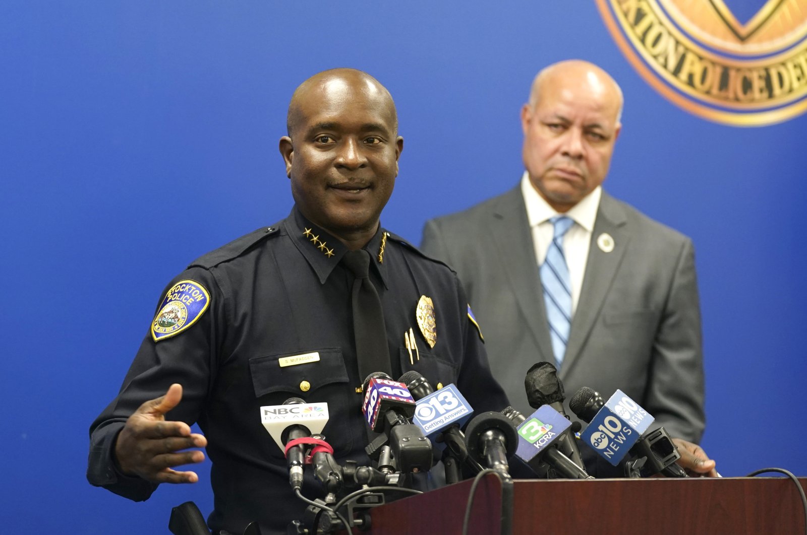 Stockton Police Chief Stanley McFadden, left, flanked by Stockton City Manager Harry Black, right, updates reporters about the investigation into the shooting deaths of six men and one woman during a news conference. Stockton, California, Oct. 4, 2022. (AP Photo)