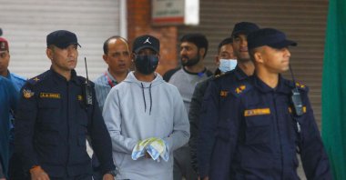 Nepali cricketer Sandeep Lamichhane (C) is escorted by police after being taken into custody to face rape charges, at Tribhuvan international airport in Kathmandu, Nepal, Oct. 6, (AFP Photo)