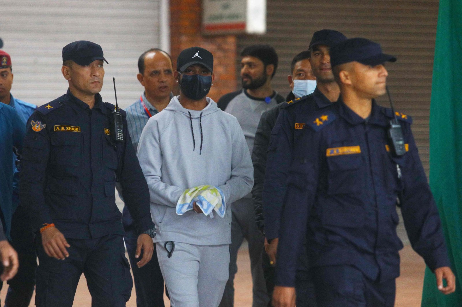 Nepali cricketer Sandeep Lamichhane (C) is escorted by police after being taken into custody to face rape charges, at Tribhuvan international airport in Kathmandu, Nepal, Oct. 6, (AFP Photo)