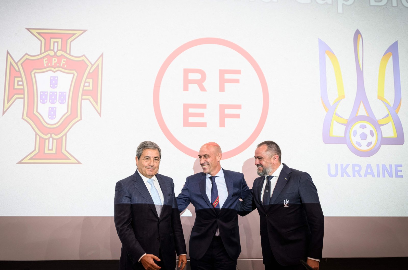 Fernando Soares Gomes da Silva (L),  Luis Rubiales (C), and  Andriy Pavelko pose during a press conference announcing Spain, Portugal and Ukraine bid for the 2030 World Cup at the UEFA headquarters. Nyon, Oct. 5, 2022. (AFP Photo)