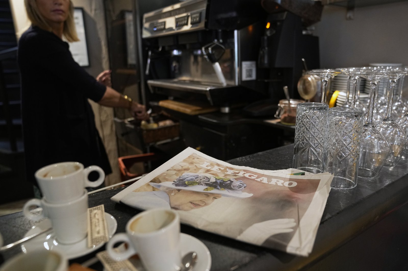 A newspaper&#039;s front page featuring a picture of Queen Elizabeth II following her death is seen near morning cups of coffee in a restaurant in Versailles, west of Paris, France, Sept. 9, 2022. (AP Photo)