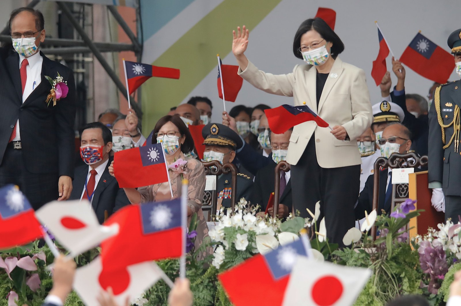 Taiwanese President Tsai Ing-wen holds a Taiwanese flag as she reacts to members of a Japanese delegation taking part in a parade during Taiwan&#039;s National Day celebrations outside the Presidential Palace, Taipei, Taiwan, Oct. 10 2022. (EPA Photo)