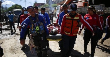 On-site officers are seen carrying a rescued citizen from a landslide caused by heavy rains, Las Tejerias, Aragua state, Venezuela, (AA Photo)