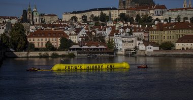Greenpeace activists place a 30-metre mock gas pipeline on the Vltava river with the Prague Castle in the background before the Meeting of the European Political Community in Prague, Czech Republic, Oct. 6, 2022. (EPA Photo)