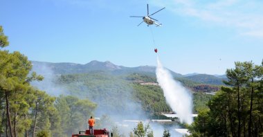 A helicopter pouring water on a burning forest, in Antalya, southern Türkiye, Oct. 10, 2022. (AA PHOTO) 