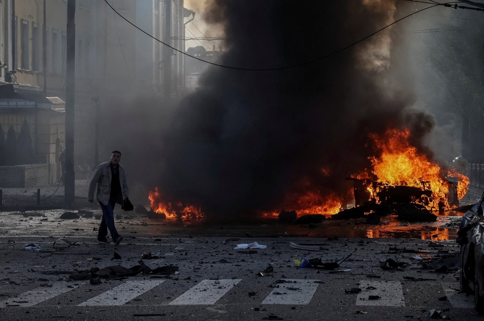 A driver walks near his burned car after Russian military strike, as Russia&#039;s invasion of Ukraine continues, in central Kyiv, Ukraine, Oct. 10, 2022.  (REUTERS Photo)
