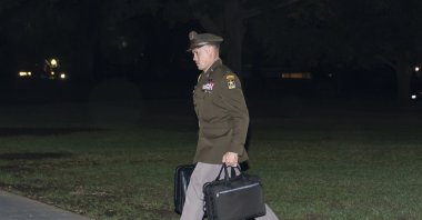 A U.S. Army officer military aide carries the nuclear launch codes known as the "football," as he follows President Joe Biden into the White House after arriving on Marine One, Washington, U.S., Oct. 6, 2022. (AP Photo)