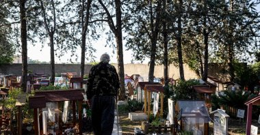 The picture shows Luigi Molon, the director of the Casa Rosa pet cemetery walks past decorated graves at the pet cemetery, Rome, Italy, Oct. 5 , 2022. (AFP Photo)