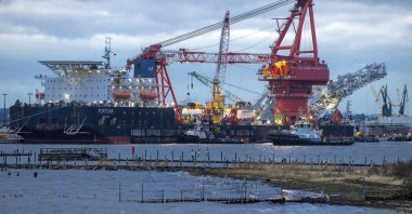 A tugboats get into position on the Russian pipe-laying vessel "Fortuna," being used for construction work on the German-Russian Nord Stream 2 gas pipeline in the Baltic Sea, in the port of Wismar, Germany, Jan. 14, 2021. (AP Photo)