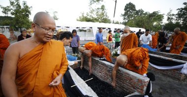 Thai Buddhist monks and the families of mass shooting victims collect the victims' ashes after the royal-sponsored mass cremation at Wat Rat Samakkee temple in Nong Bua Lamphu province, northeastern Thailand, Oct. 12, 2022. (EPA Photo)