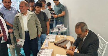 Former Yemeni Ambassador to Bulgaria and writer Abdul Razzaq al-Amrani signs his book “Bulgaria from the Eastern Corner” at the Istanbul International Arab Book Fair, Türkiye, Oct. 1, 2022 (Photo by Mohamad Alhoussain)