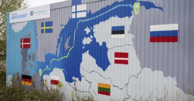 A sign reading &quot;Nord Stream 2 Committed. Reliable. Safe.&quot; hangs above a painted map of the Nord Stream 2 pipeline from Russia to Germany at the natural gas receiving station in Lubmin, Germany, Nov. 16, 2021. (AP Photo)