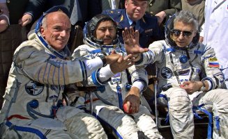 U.S. space tourist Dennis Tito (L) shakes hands with his crew members Talgat Musabayev (C) and Yuri Baturin (R) after their landing near the Kazakh town of Arkalyk, May 6, 2001. (Photo by Alexander NEMENOV / AFP)