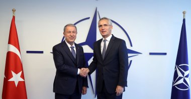 Defense Minister Hulusi Akar shakes hands with NATO chief Jens Stoltenberg in Brussels, Belgium, Oct. 12, 2022. (IHA Photo)