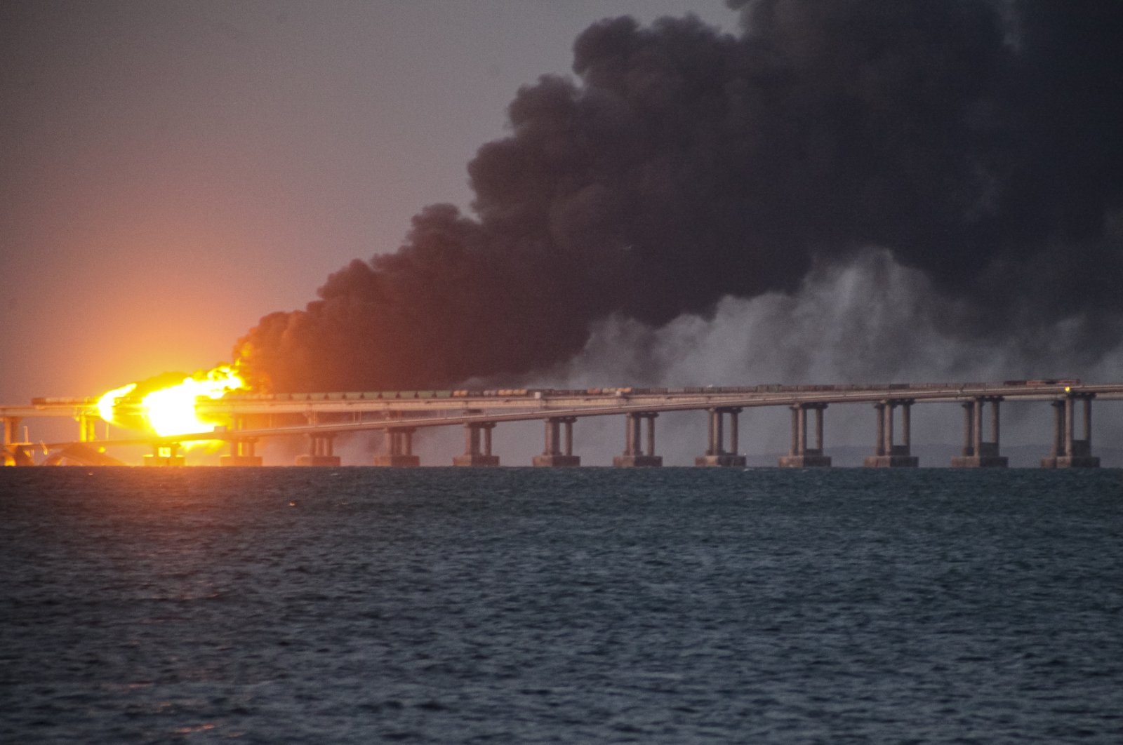 Flame and smoke rise from Crimean Bridge connecting the Russian mainland and the Crimean Peninsula over the Kerch Strait, Kerch, Crimea, Ukraine, Oct. 8, 2022. (AP Photo)