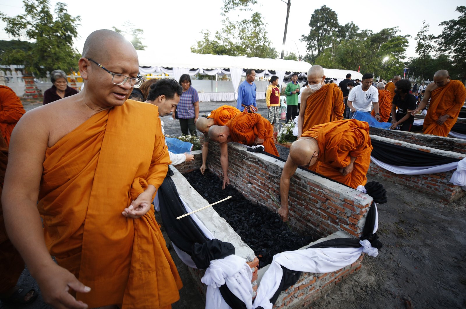 Thai Buddhist monks and the families of mass shooting victims collect the victims&#039; ashes after the royal-sponsored mass cremation at Wat Rat Samakkee temple in Nong Bua Lamphu province, northeastern Thailand, Oct. 12, 2022. (EPA Photo)