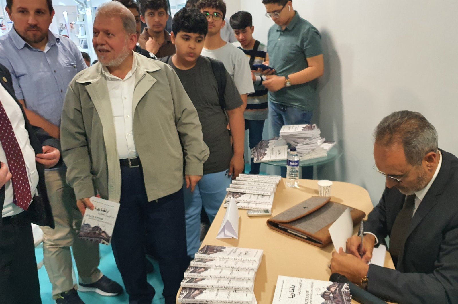 Former Yemeni Ambassador to Bulgaria and writer Abdul Razzaq al-Amrani signs his book “Bulgaria from the Eastern Corner” at the Istanbul International Arab Book Fair, Türkiye, Oct. 1, 2022 (Photo by Mohamad Alhoussain)