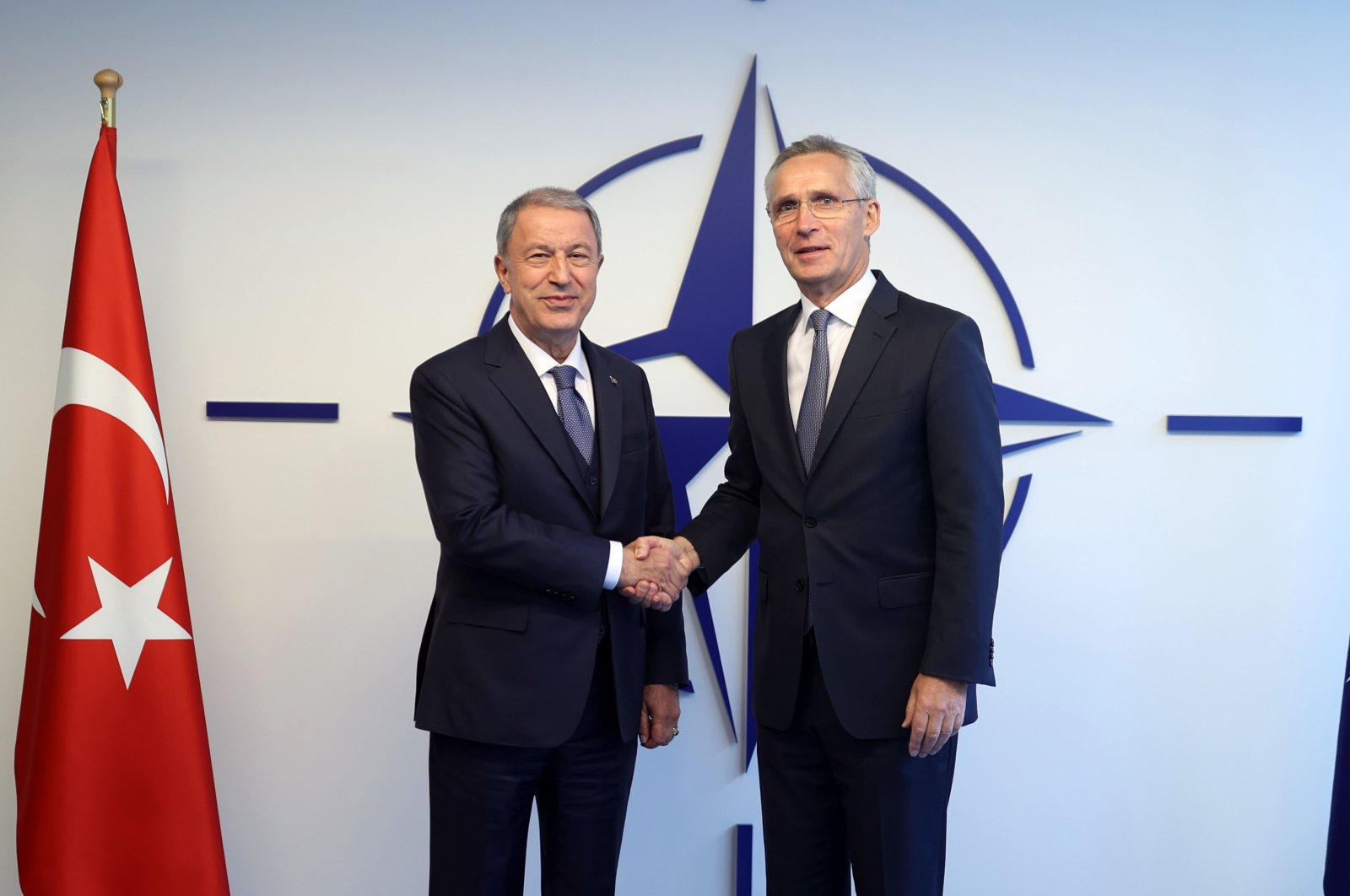 Defense Minister Hulusi Akar shakes hands with NATO chief Jens Stoltenberg in Brussels, Belgium, Oct. 12, 2022. (IHA Photo)