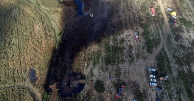 Firefighters work in the field near the Druzhba pipeline where an oil leak was detected, near the village of Zurawice, Poland, Oct.12, 2022. (Reuters Photo)