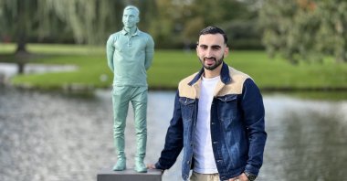 Alihan Uzun stands next to the statue of himself in a park in Hendrik-Ido-Ambacht, Netherlands, Oct. 13, 2022. (AA Photo)