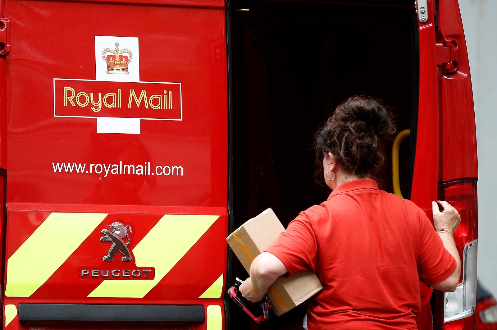 A postal worker makes a delivery in London, Britain, July 21, 2022. (Reuters Photo)