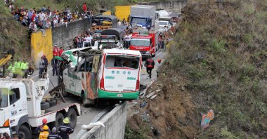 People watch as rescuers try to secure a bus after an accident on the Pan-American Highway in Altos de Penalisa, near the city of Pasto, Narino, Colombia, Oct. 15, 2022. (AFP Photo)