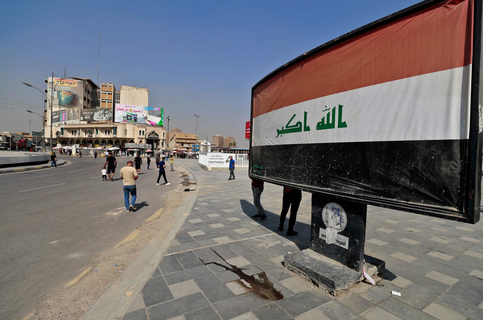 Iraqis walk in a street after security forces blocked a road leading to the Green Zone in Baghdad on Oct. 13, 2022 as lawmakers gathered for their fourth attempt this year to elect a new state president and break political gridlock that has sparked deadly violence. (AFP Photo)