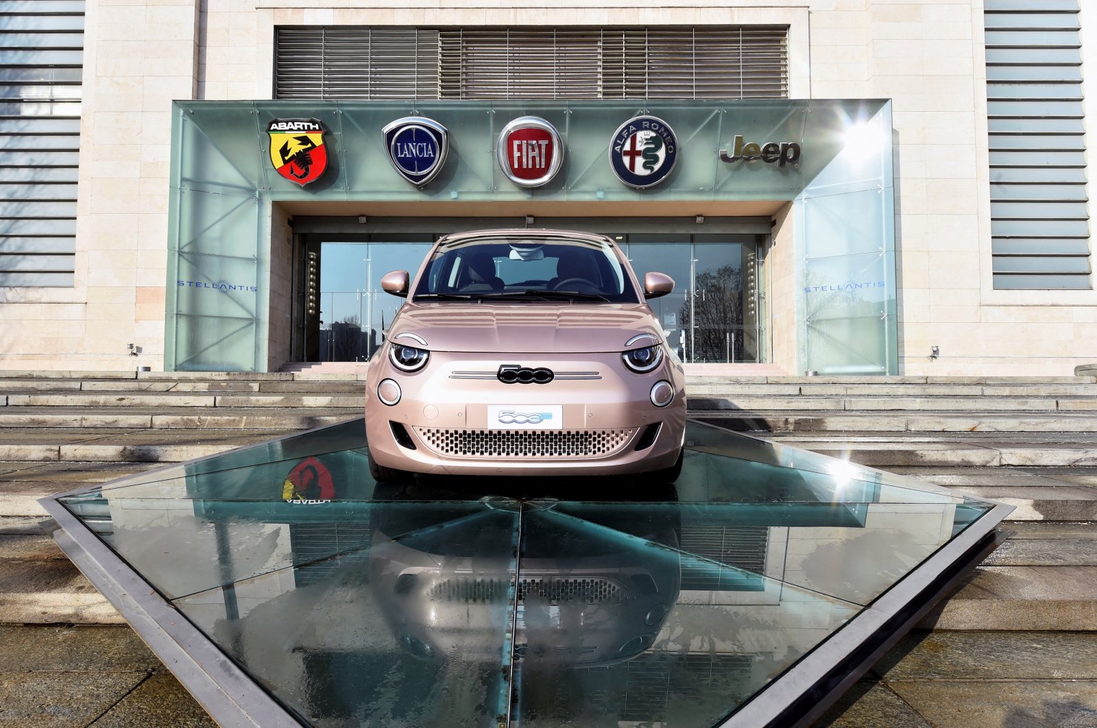 The logo of Stellantis, the world&#039;s fourth-largest automaker which starts trading in Milan and Paris after Fiat Chrysler and Peugeot maker PSA finalized their merger, is seen next to a car displayed at the main entrance of FCA Mirafiori plant in Turin, Italy, Jan. 18, 2021. (Reuters File Photo)