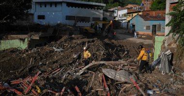 Rescuers walk through the rubble of destroyed houses as they search for victims days after a devastating landslide, Las Tejerias Aragua state, Venezuela, Oct. 14, 2022. (AFP Photo)