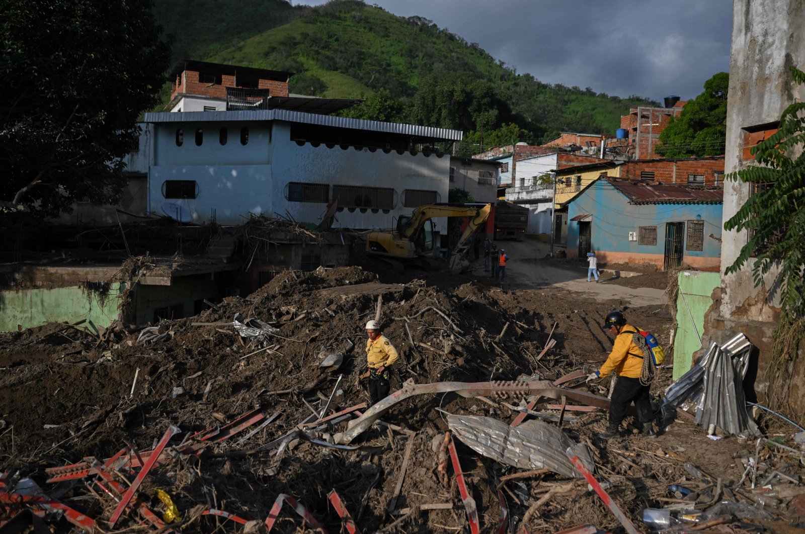 Rescuers walk through the rubble of destroyed houses as they search for victims days after a devastating landslide, Las Tejerias Aragua state, Venezuela, Oct. 14, 2022. (AFP Photo)