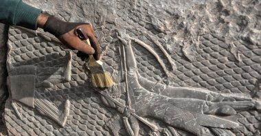 An Iraqi worker excavates a rock-carving relief recently found at the Mashki Gate, one of the monumental gates to the ancient Assyrian city of Nineveh, on the outskirts of Mosul, Iraq, Oct. 19, 2022. (AFP Photo)